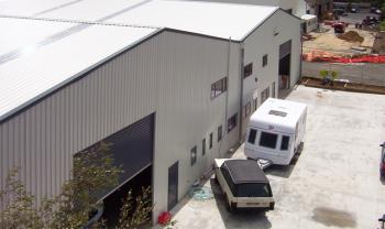 white industrial shed with car parked outside