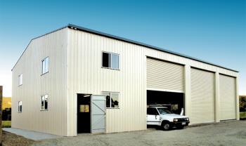 white industrial shed with car standing at door
