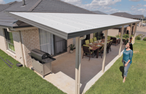 sheds installed at backside sitting area of house with lady in front